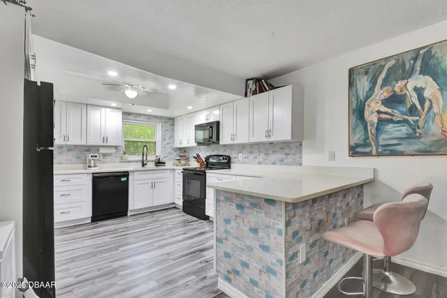 a kitchen with stainless steel appliances granite countertop a white cabinets and wooden floor