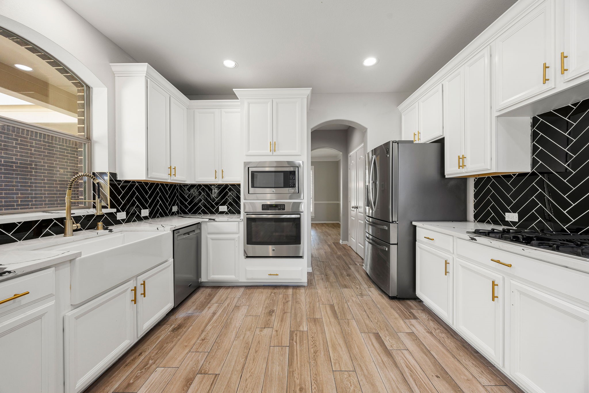 3407 Cardiff Mist Drive Katy, TX 77494 - Photo 9 of 28 This stunning kitchen displays such a beautiful contrast with the white stained cabinets, dark Herringbone backsplash, custom neutral paint, countertops, SS appliances, breakfast bar, recessed lighting, high ceilings and pantry.