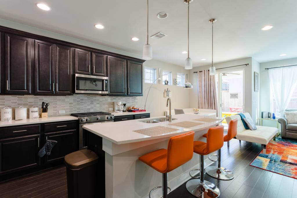 807 East 16th Street, Unit A Austin, TX 78702 - Photo 10 of 29 a kitchen with stainless steel appliances granite countertop a sink a stove a refrigerator cabinets and chairs