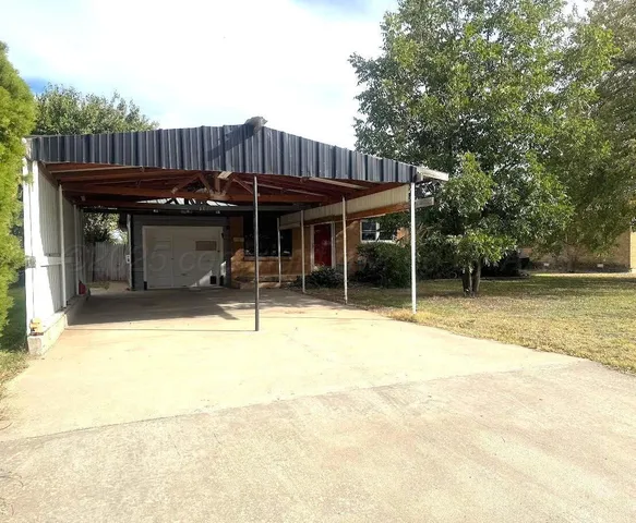 a view of a house with wooden deck and furniture