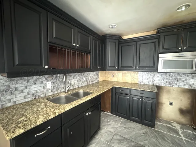 a kitchen with a sink and wooden cabinets