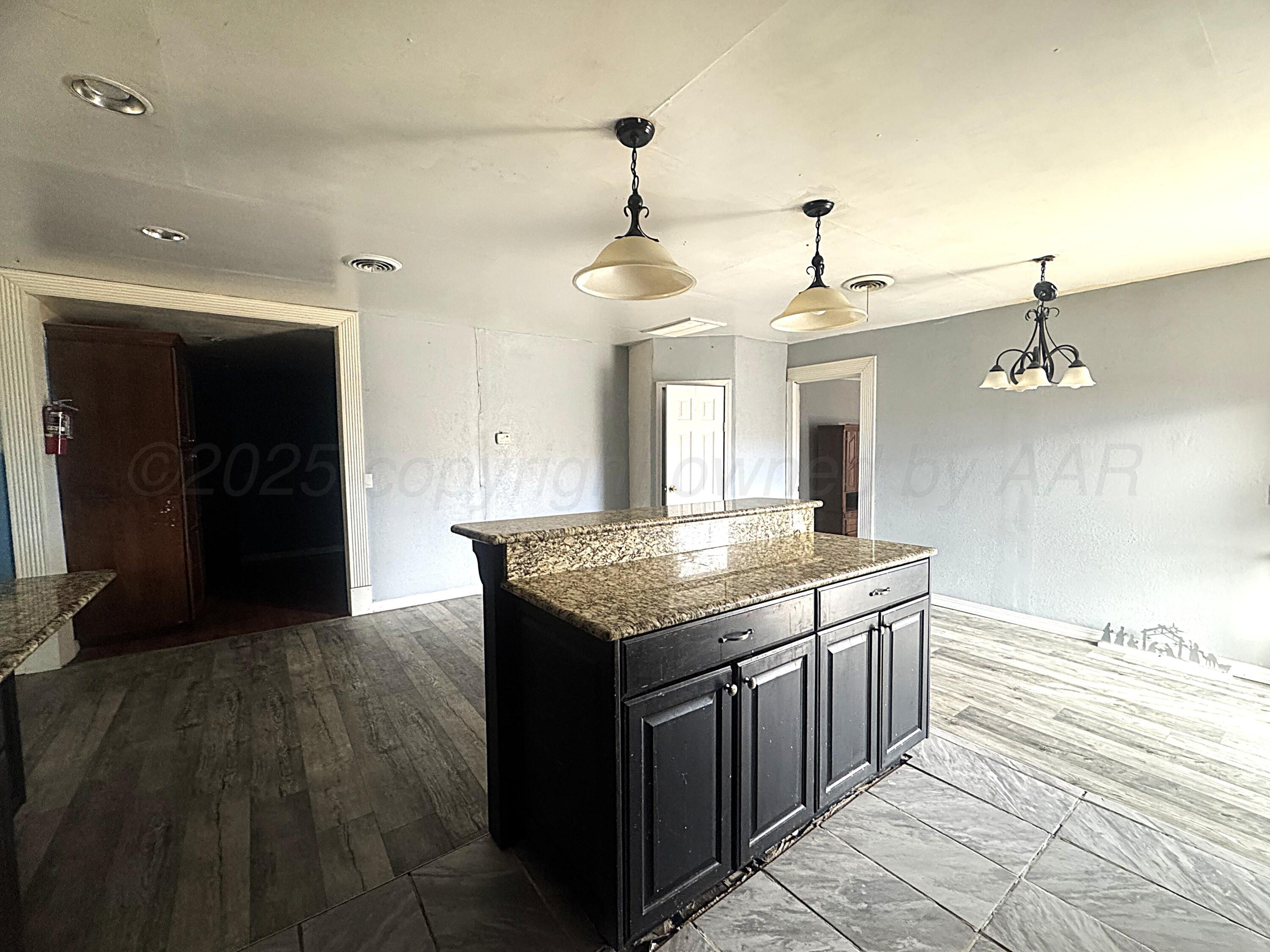 1713 South Drake Street Perryton, TX 79070 - Photo 7 of 13 a kitchen with stainless steel appliances granite countertop a stove and a refrigerator