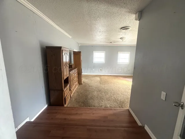 a view of hallway with wooden floor and a rug