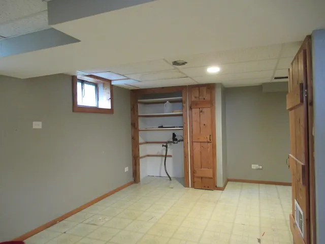 a view of an empty room with a cabinet and a window