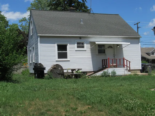 a front view of house with yard and outdoor seating