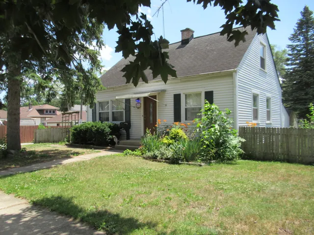a view of a house with a yard and potted plants