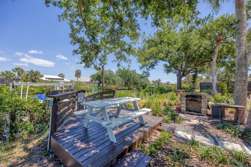 4624 Pompano Street Placida, FL 33946 - Photo 28 of 39 a view of a wooden deck with chairs and a yard