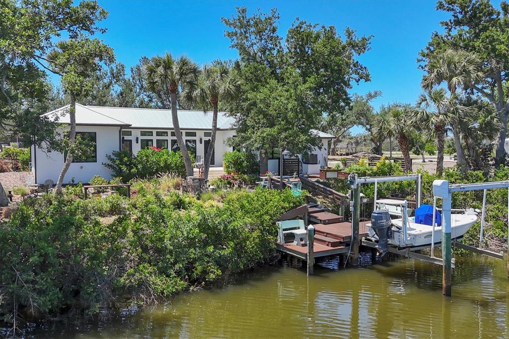 4624 Pompano Street Placida, FL 33946 - Photo 33 of 39 a view of a lake with a house a table and chairs