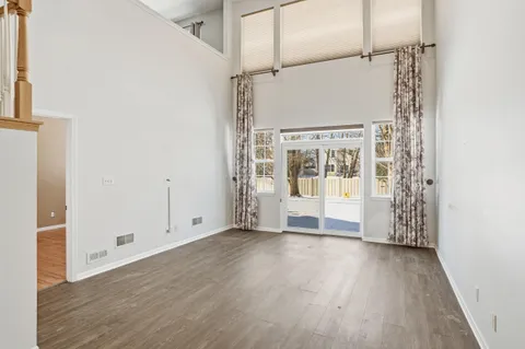 a view of a big room with wooden floor and windows