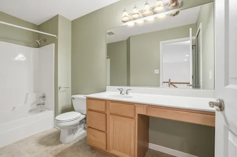 a bathroom with a sink a toilet and a large mirror