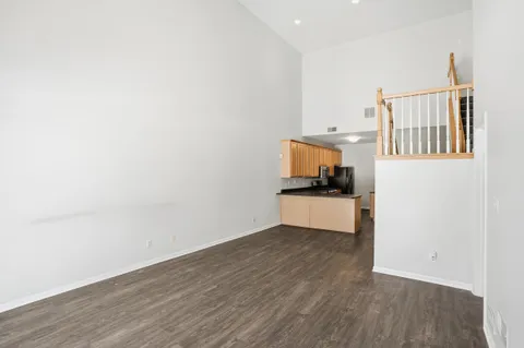 a view of a kitchen with wooden floor and electronic appliances