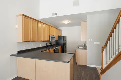 a kitchen with stainless steel appliances granite countertop a sink a stove and a refrigerator