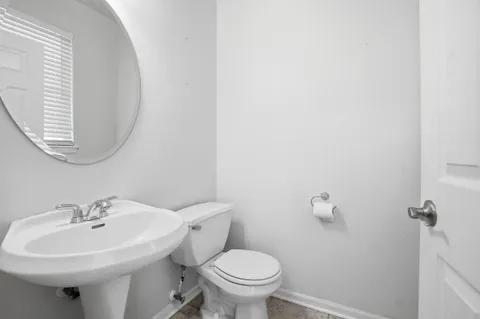 a bathroom with a sink a toilet and a mirror