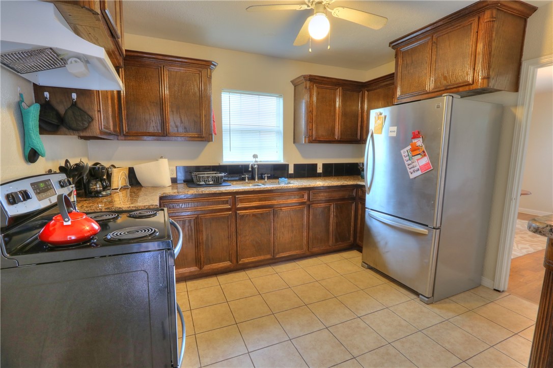 3538 Austin Street Corpus Christi, TX 78411 - Photo 11 of 21 a kitchen with stainless steel appliances granite countertop a refrigerator sink stove and cabinets