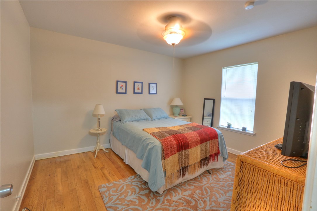 3538 Austin Street Corpus Christi, TX 78411 - Photo 19 of 21 a bedroom with a bed and a flat tv screen on a dresser