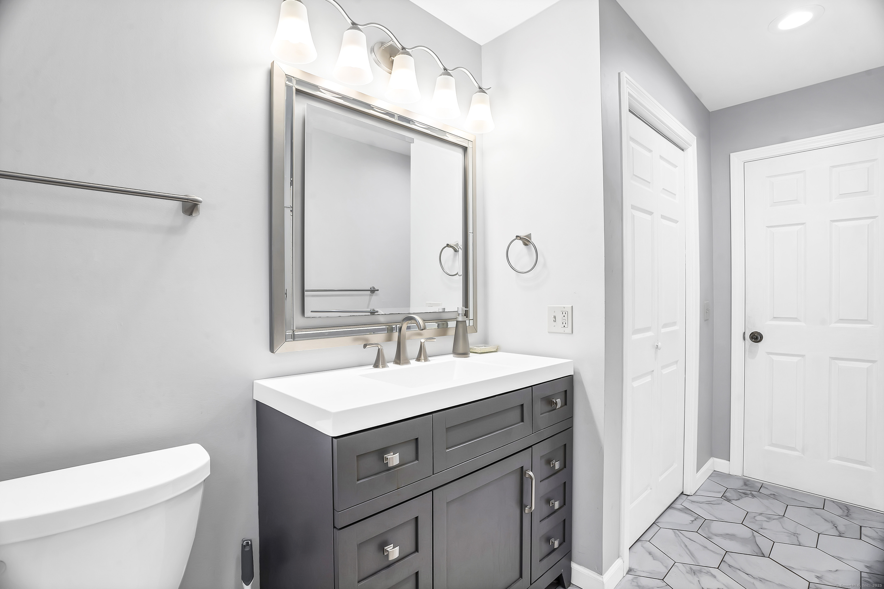 132 Howard Avenue Ansonia, CT 06401 - Photo 14 of 16 a bathroom with a toilet a sink a vanity and mirror