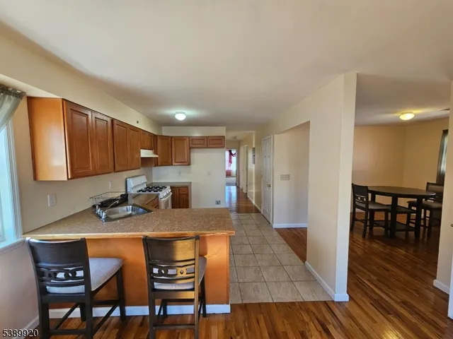 a kitchen with granite countertop a table chairs stove and cabinets