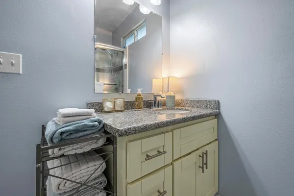 a bathroom with a granite countertop sink a toilet and a mirror