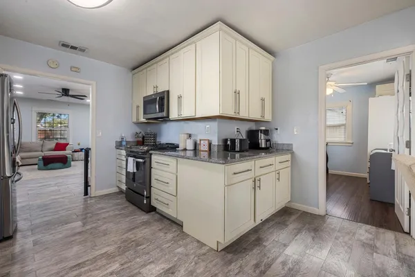 a kitchen with stainless steel appliances granite countertop a stove a sink and a refrigerator