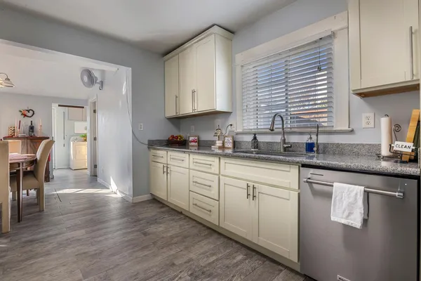 a kitchen with granite countertop a stove a sink and cabinets