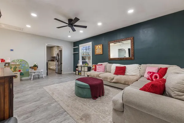 a living room with furniture and a ceiling fan