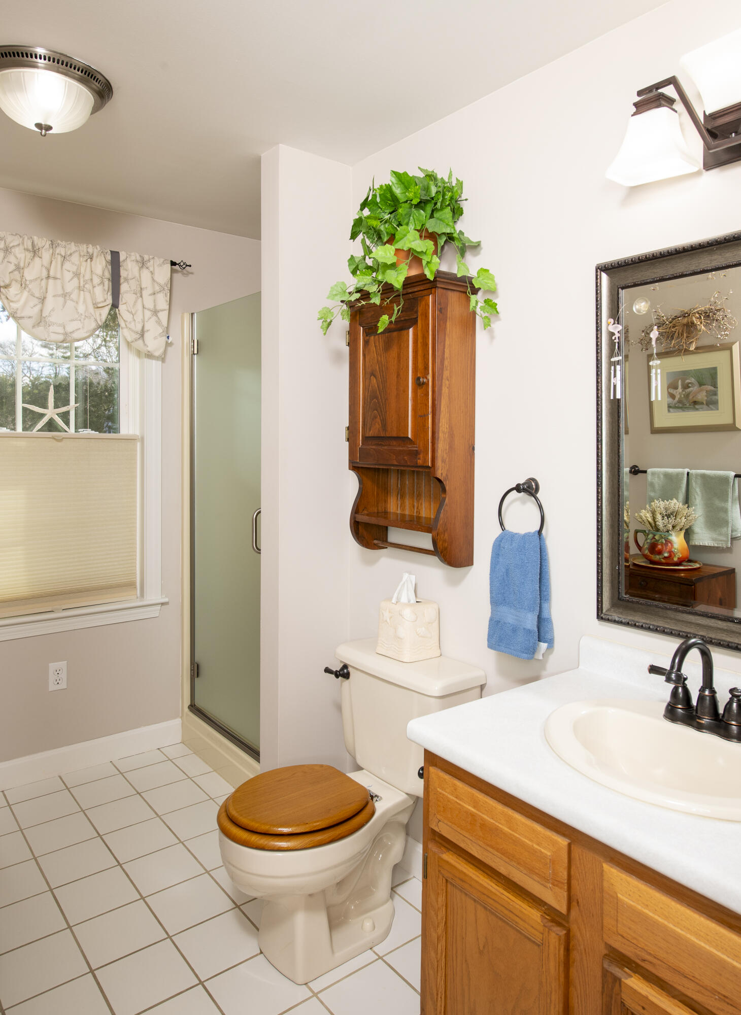31 Mashpee Neck Road Mashpee, MA 02649 - Photo 21 of 65 a bathroom with a sink toilet and mirror