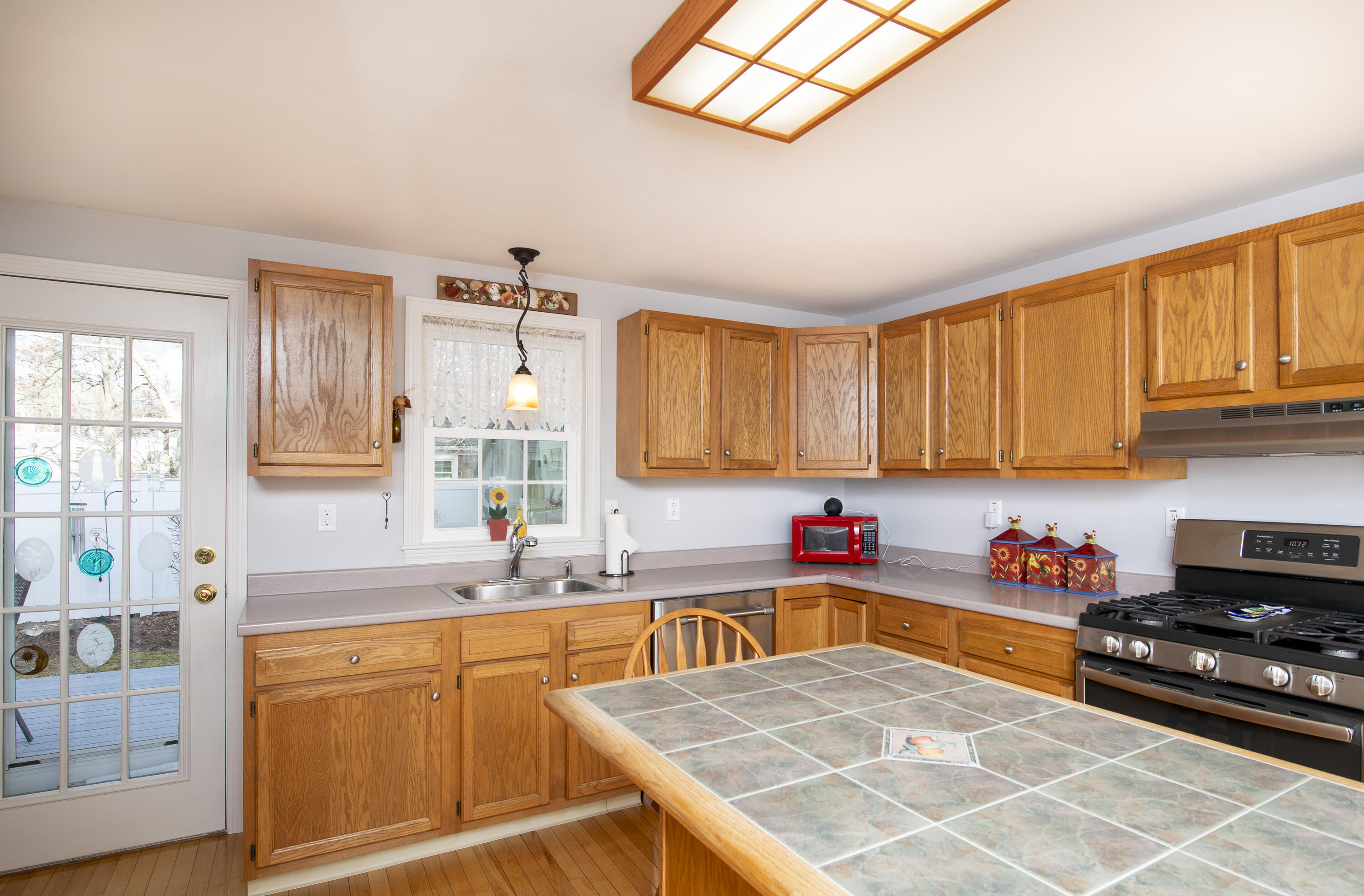 31 Mashpee Neck Road Mashpee, MA 02649 - Photo 8 of 65 a kitchen with stainless steel appliances granite countertop a sink dishwasher stove and cabinets with wooden floor