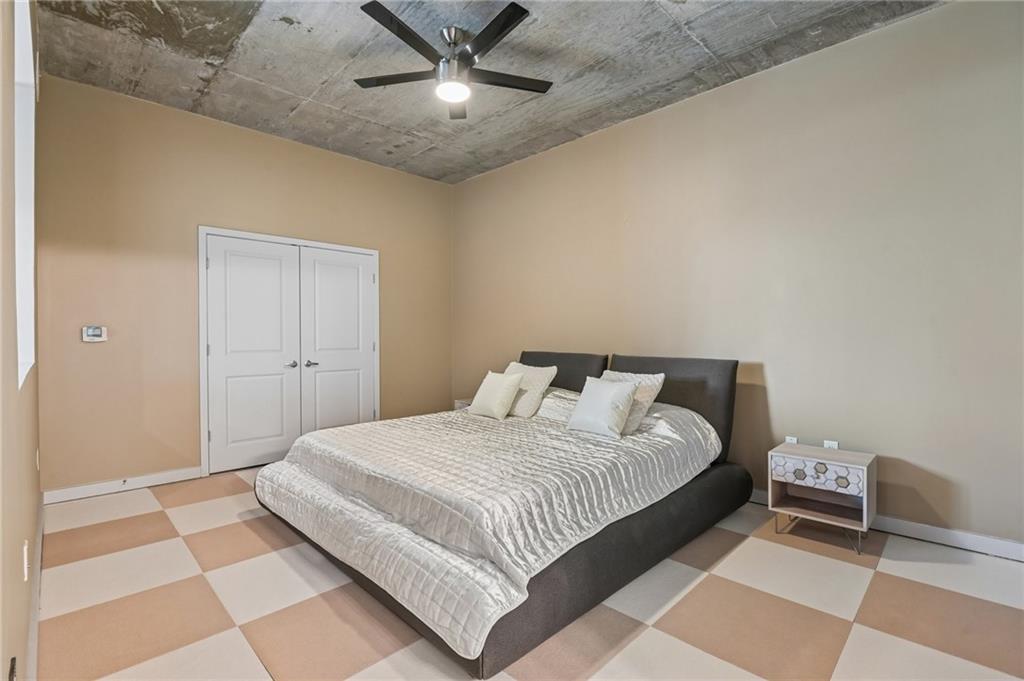 250 Pharr Road Northeast, Unit 701 Atlanta, GA 30305 - Photo 8 of 21 a bedroom with a large bed and a chandelier
