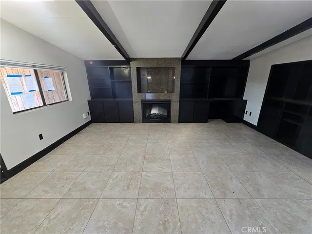 a view of an empty room with closet and windows