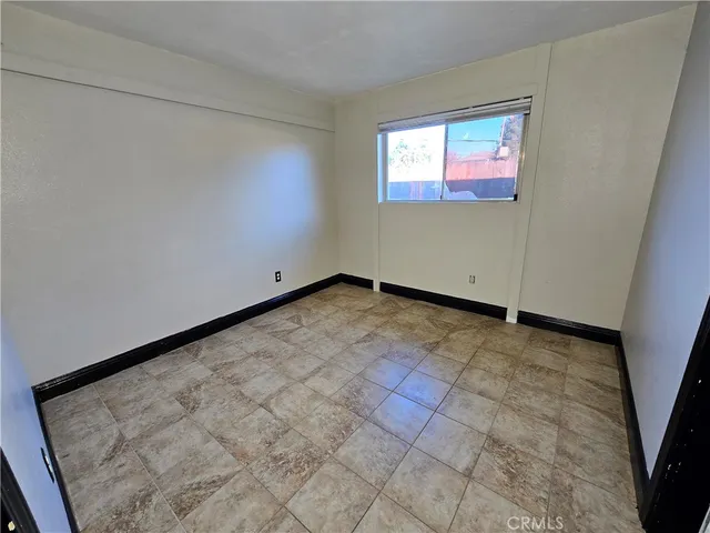a view of a room with a refrigerator and cabinets