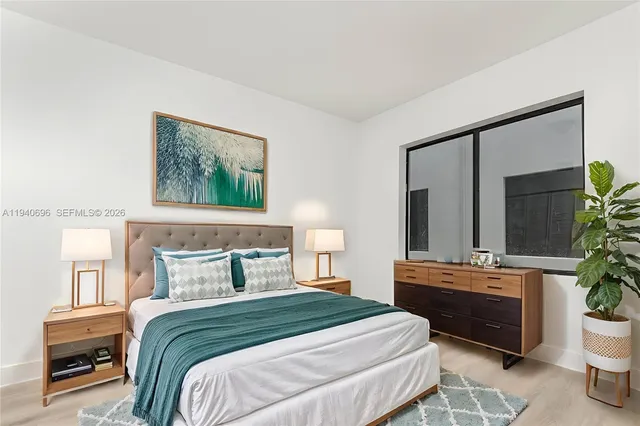 a bedroom with a bed a potted plant and a dresser