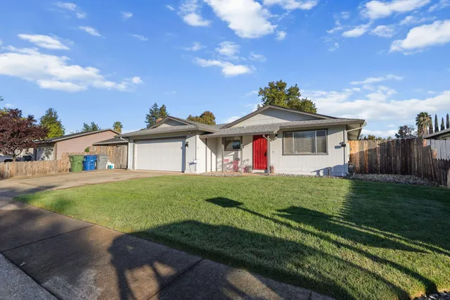 a view of a house with a big yard plants and large trees
