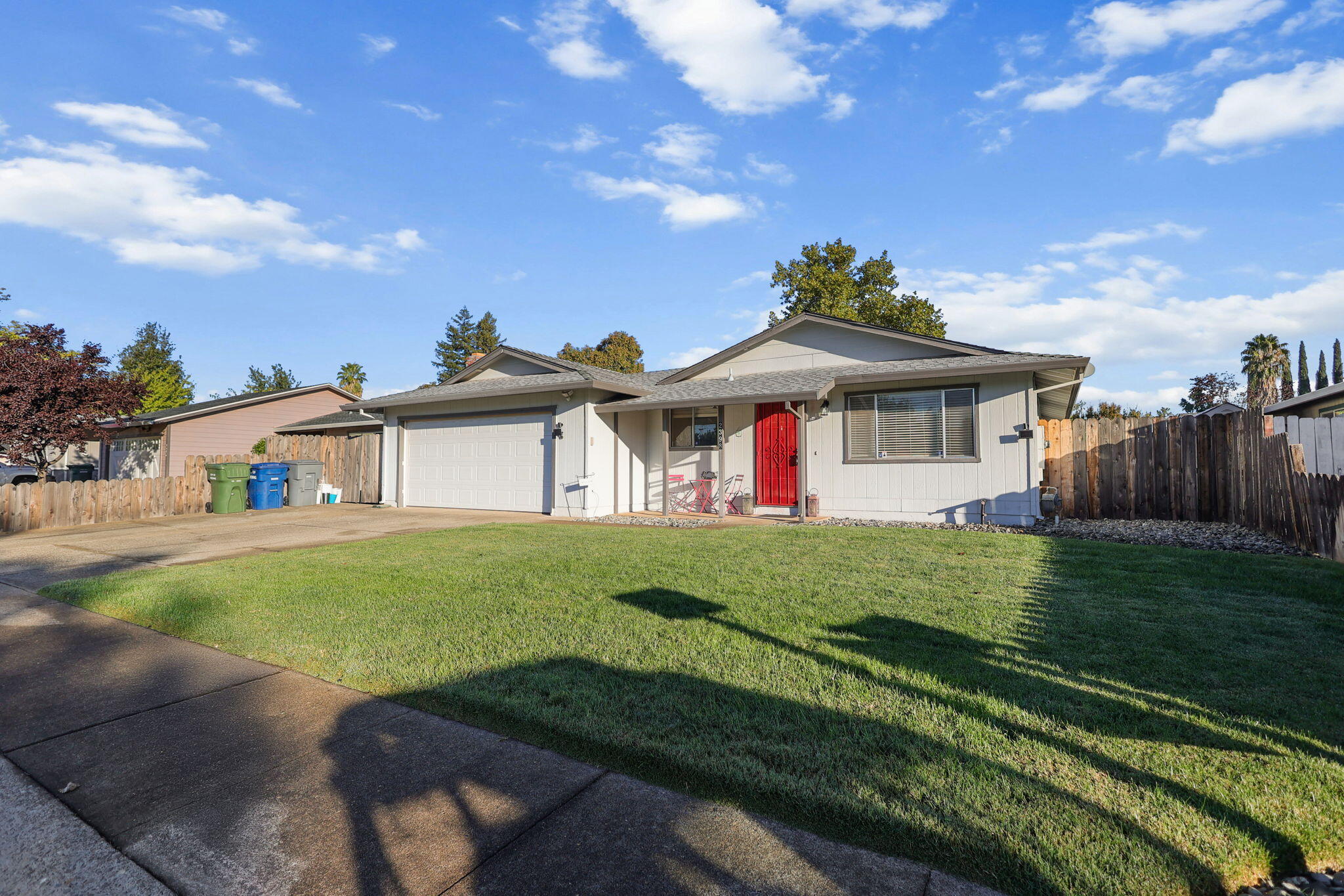 a view of a house with a big yard plants and large trees