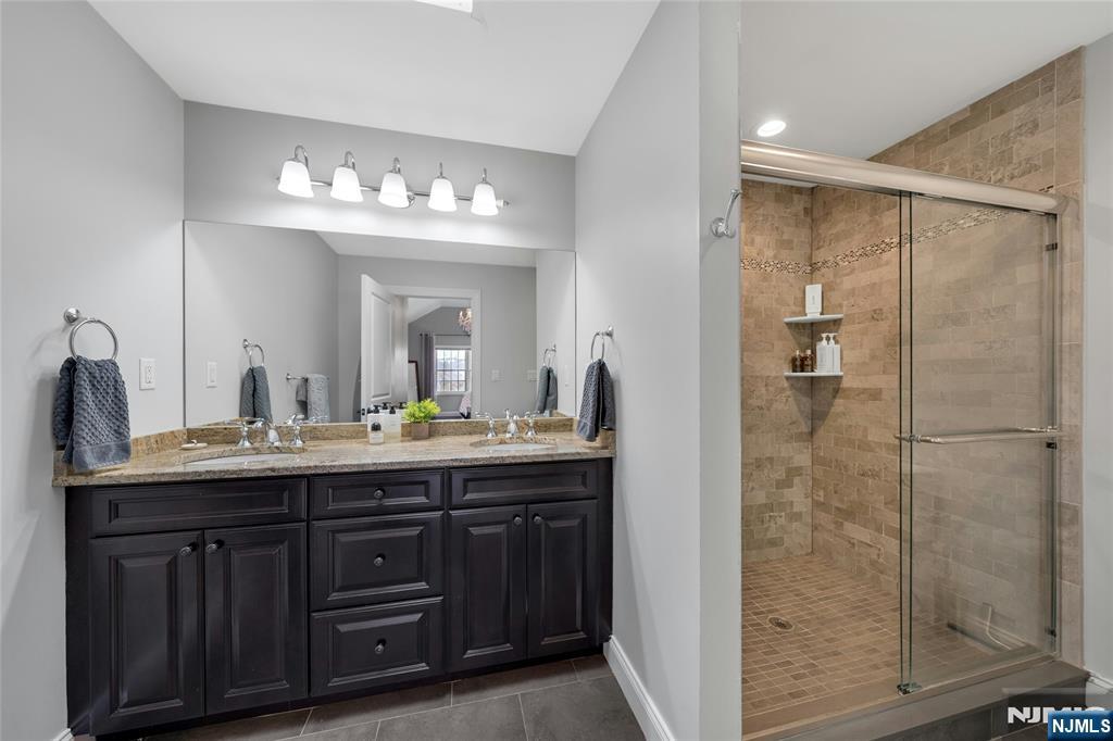 51 Terrace Street Park Ridge, NJ 07656 - Photo 20 of 29 a bathroom with a granite countertop sink a mirror and a shower