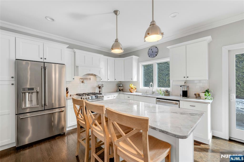 51 Terrace Street Park Ridge, NJ 07656 - Photo 5 of 29 a kitchen with stainless steel appliances granite countertop a sink a stove a refrigerator and island with wooden floor