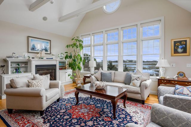 a living room with furniture fireplace and a large window