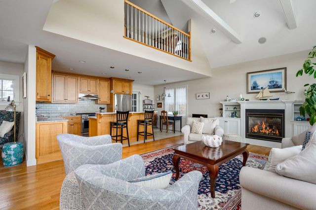 a living room with furniture kitchen view and a fireplace