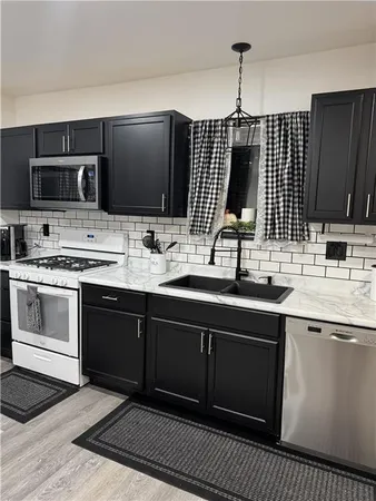 a kitchen with stainless steel appliances a sink stove and microwave
