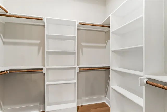 a view of walk in closet with empty racks