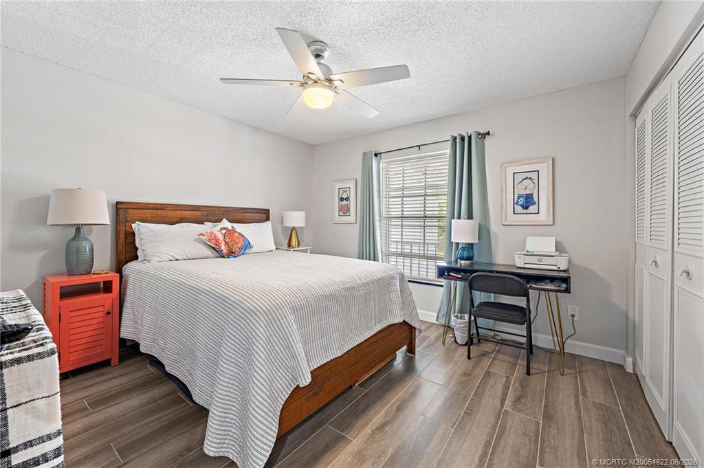 1862 Southwest Palm City Road, Unit 203 Stuart, FL 34994 - Photo 25 of 39 a bedroom with a bed and wooden floor
