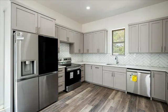 a kitchen with stainless steel appliances granite countertop a refrigerator sink and stove