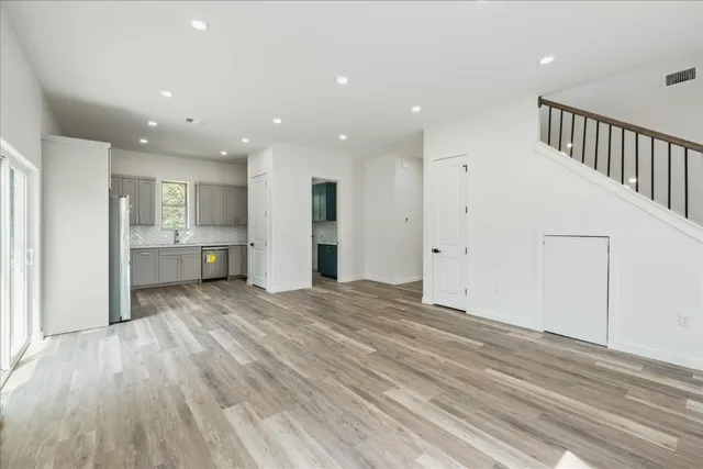 a view of empty room with wooden floor