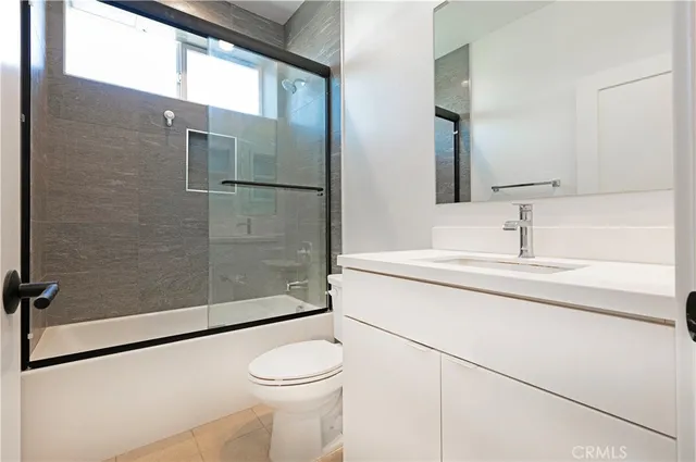 a bathroom with a sink a toilet a mirror and shower