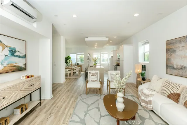 a living room with furniture a flat screen tv and a dining table