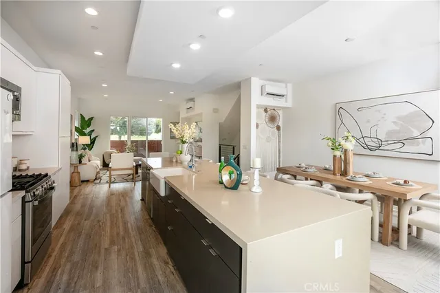 a large kitchen with stainless steel appliances a lot of counter space and a wooden floor