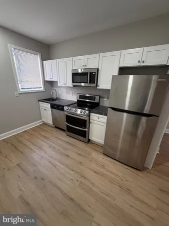 a kitchen with stainless steel appliances a refrigerator sink and microwave