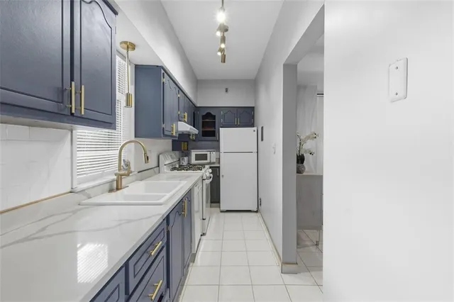 a kitchen with a sink a refrigerator and cabinets