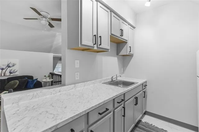 a large white kitchen with a sink and dishwasher a stove with wooden floor