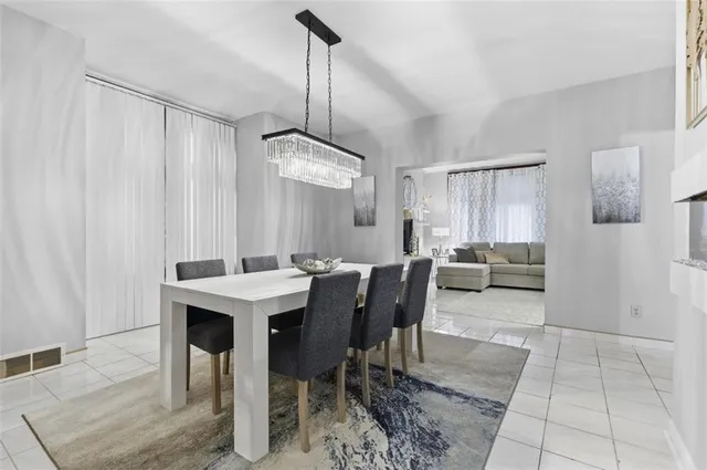 a view of a dining room and livingroom with furniture wooden floor a chandelier
