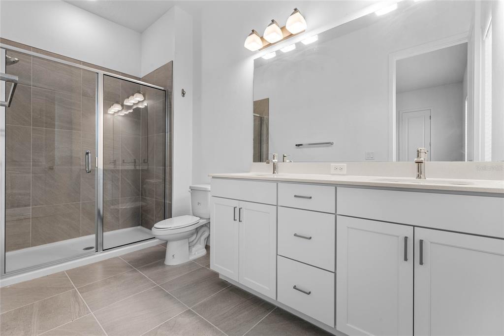 38 West Harding Street, Unit B Orlando, FL 32806 - Photo 19 of 27 a bathroom with a toilet a shower a sink and mirror